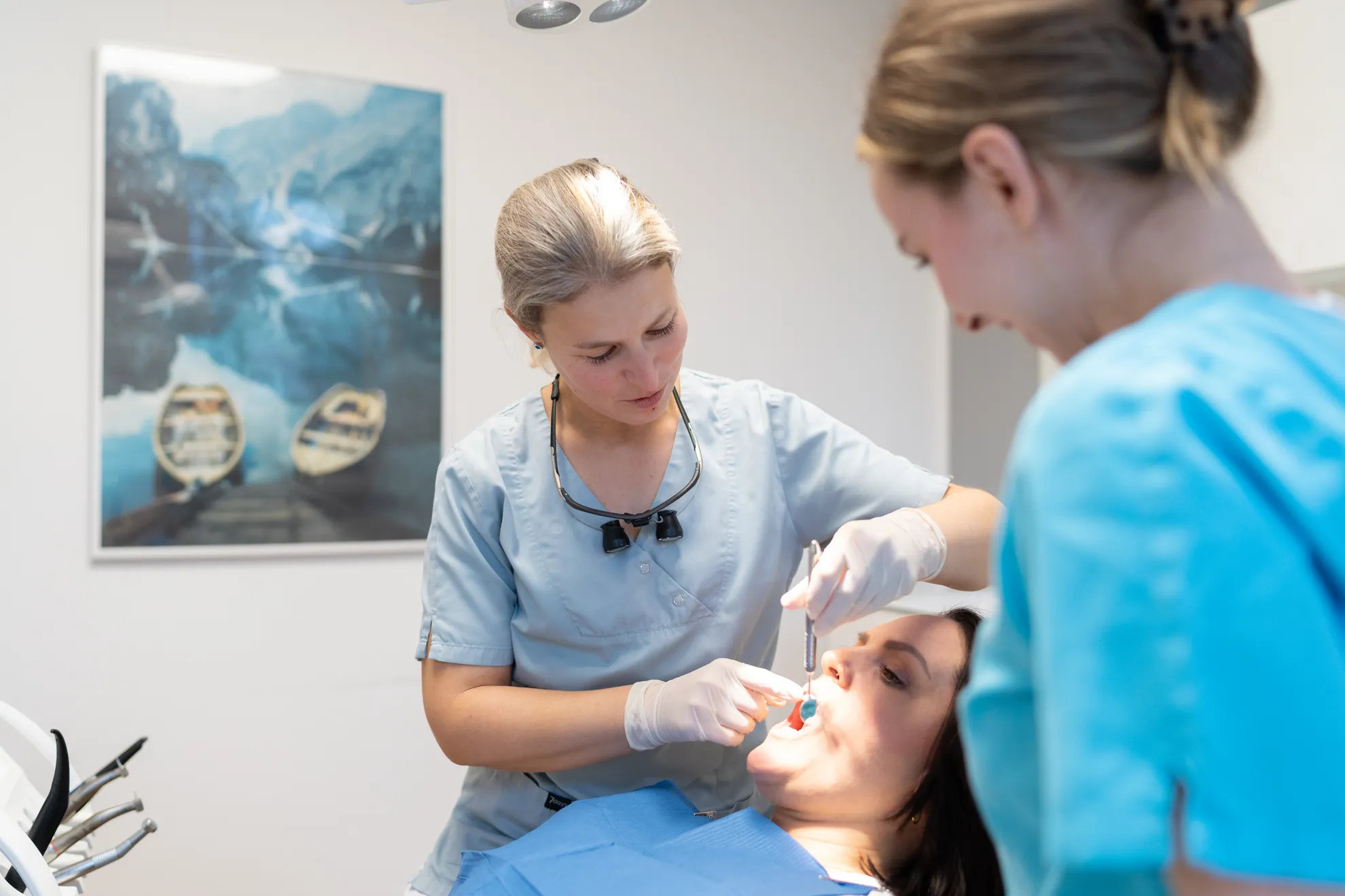 Zahnärztin & ZFA behandeln Patientin an den Zähnen